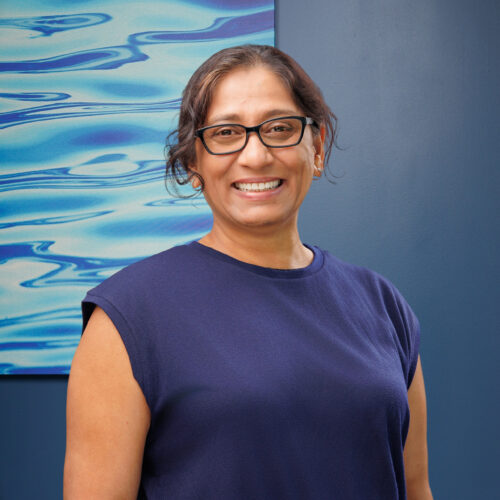 A woman standing in front of a painting.