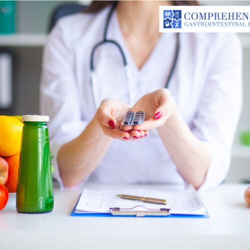 Nutritionist holding an unopened tablet with fruits and a paper on the table.