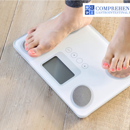 Person standing on a weight scale with bare feet on the floor.